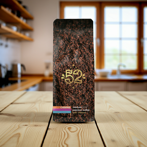 Coffee packaging with '52' branding on a wooden table in a kitchen setting